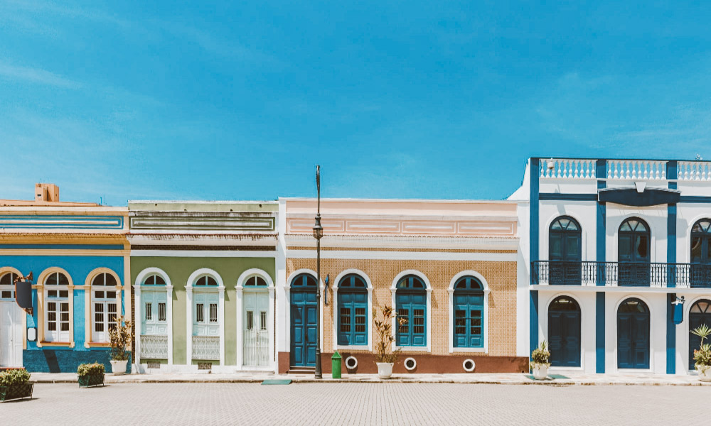 Casas antigas coloridas enfileiradas em uma rua com céu azul